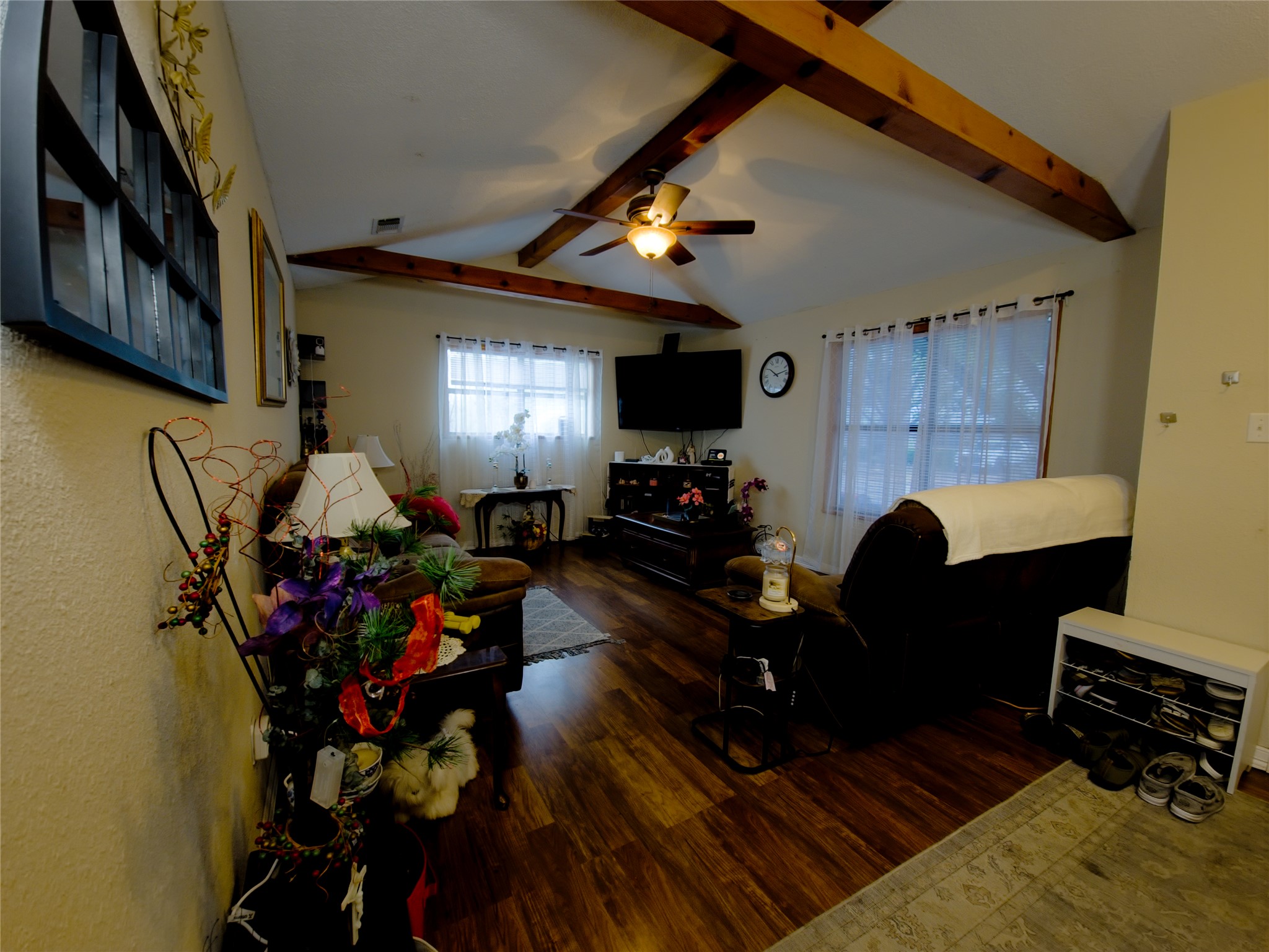 911 Brazos Street Lockhart, TX 78644 - Photo 6 of 22 Living area featuring dark wood-type flooring, a ceiling fan, and beam ceiling