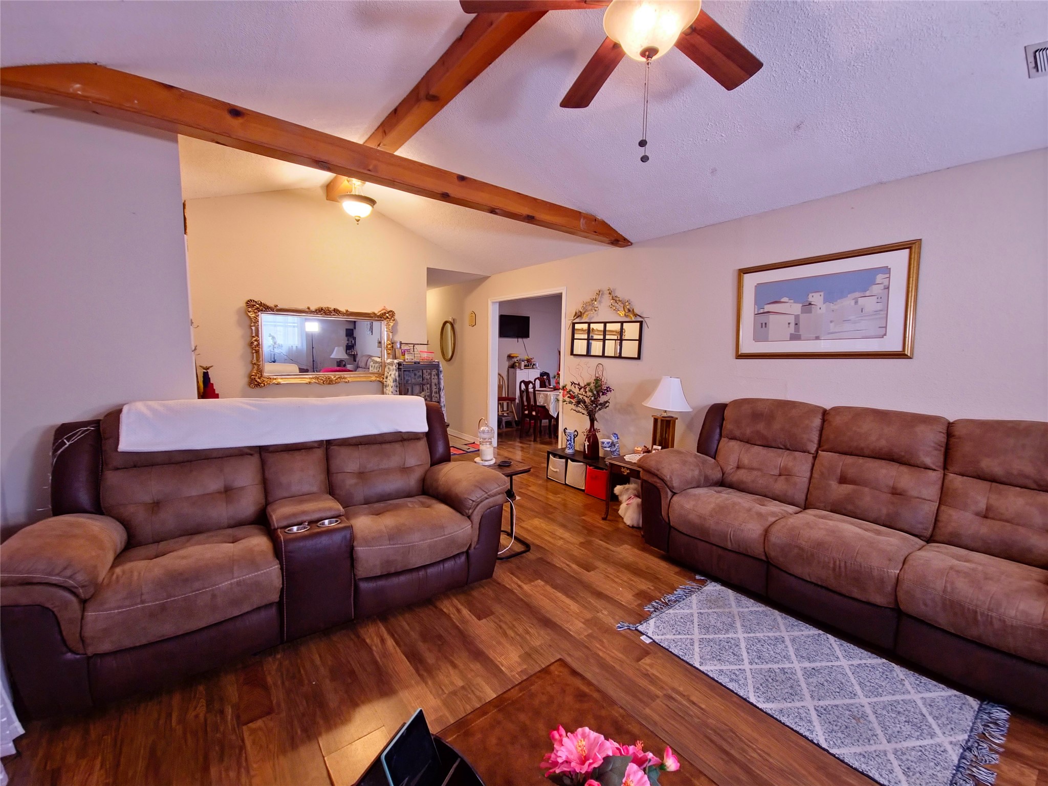 911 Brazos Street Lockhart, TX 78644 - Photo 7 of 22 Living room featuring a ceiling fan, wood finished floors, and beamed ceiling