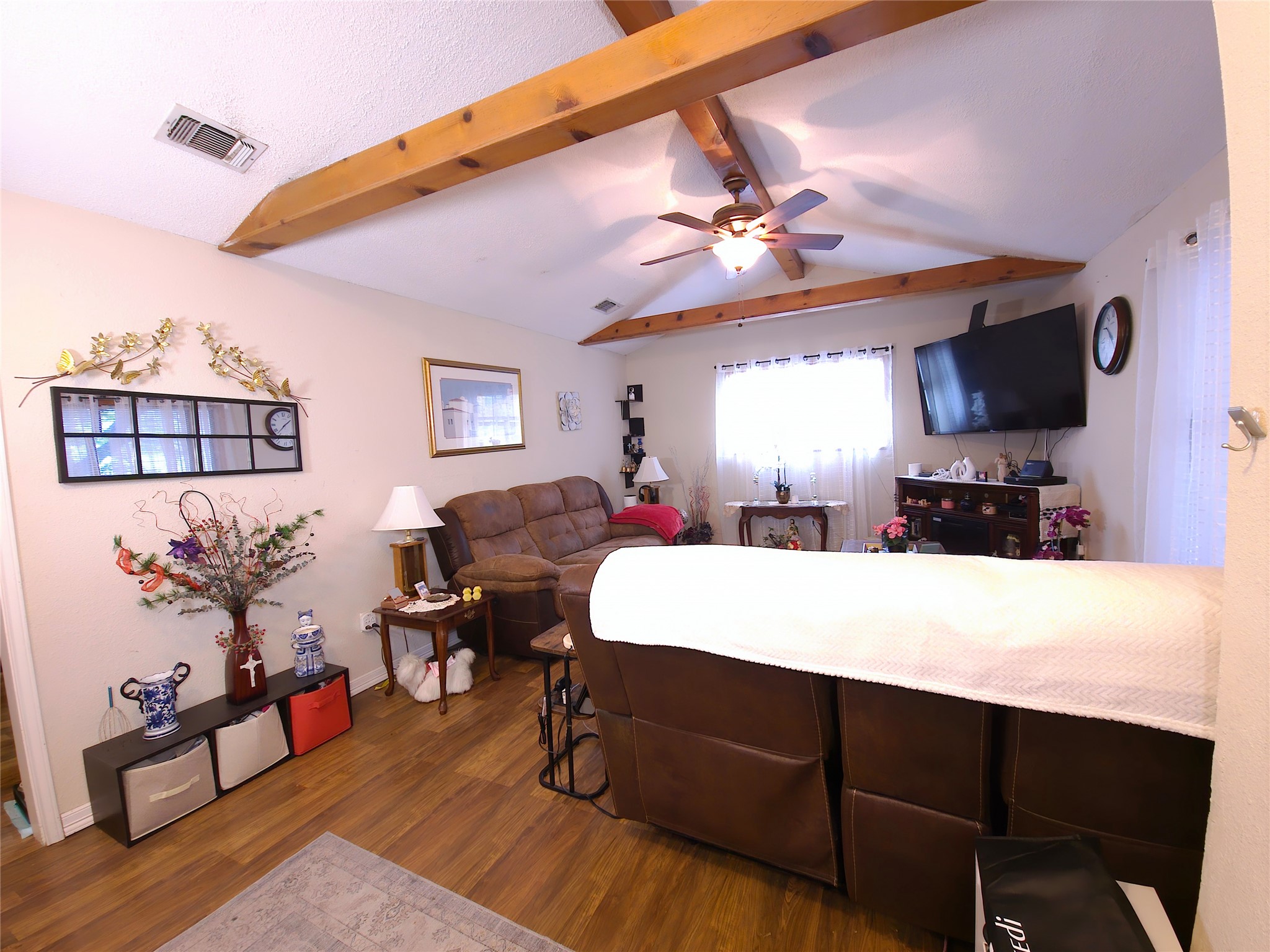 911 Brazos Street Lockhart, TX 78644 - Photo 8 of 22 Bedroom featuring dark wood-style floors, beamed ceiling, and a ceiling fan