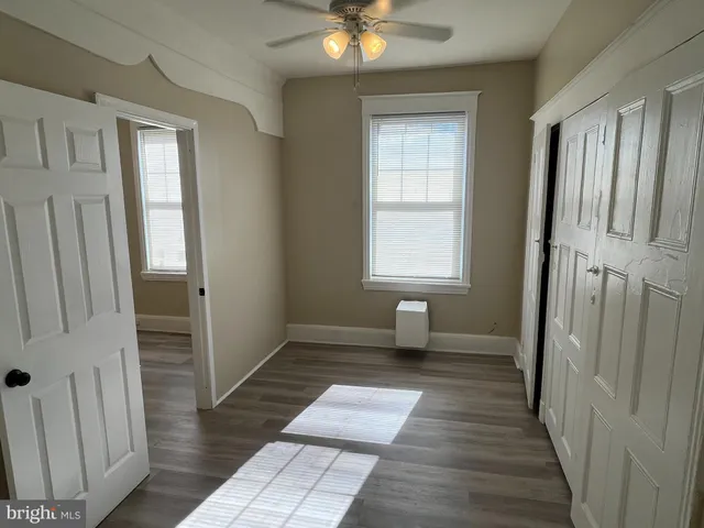 a view of a room with wooden floor and a window