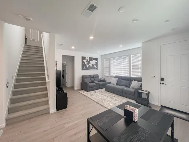 a living room with furniture and a wooden floor