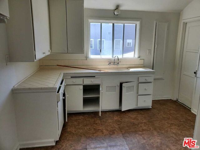 a room with a sink cabinets and utility room