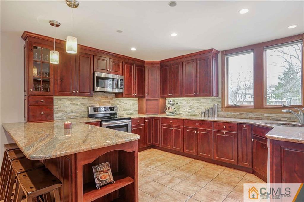 342 Pleasant Valley Road Old Bridge, NJ 08857 - Photo 3 of 25 a kitchen with a stove a sink and a microwave