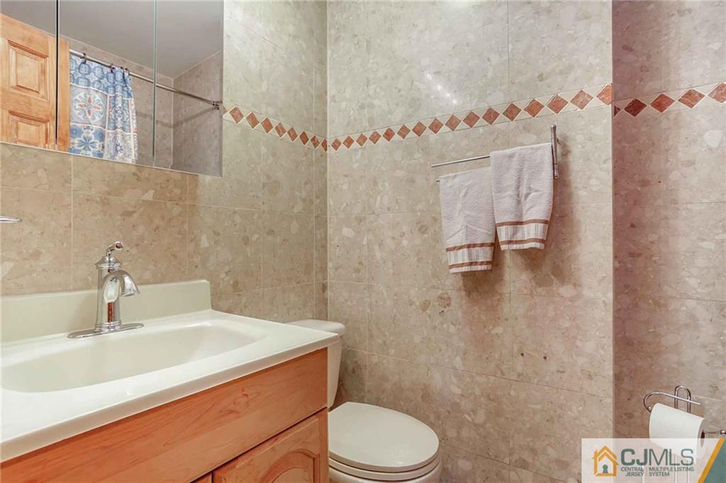 342 Pleasant Valley Road Old Bridge, NJ 08857 - Photo 21 of 25 a bathroom with a sink a toilet and shower curtain