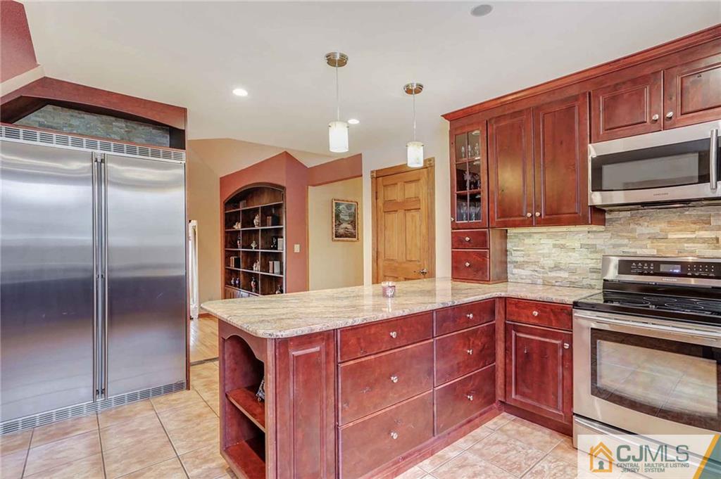 342 Pleasant Valley Road Old Bridge, NJ 08857 - Photo 4 of 25 a kitchen with stainless steel appliances granite countertop a stove refrigerator and cabinets