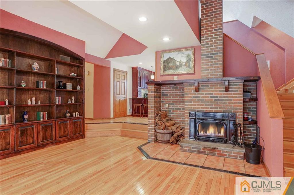 342 Pleasant Valley Road Old Bridge, NJ 08857 - Photo 9 of 25 a living room with furniture a fireplace and a book shelf