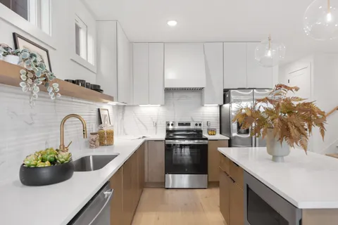 a kitchen with stainless steel appliances a sink a counter top space cabinets and living room view