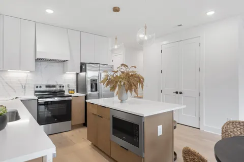a kitchen with kitchen island a stove a sink and a refrigerator