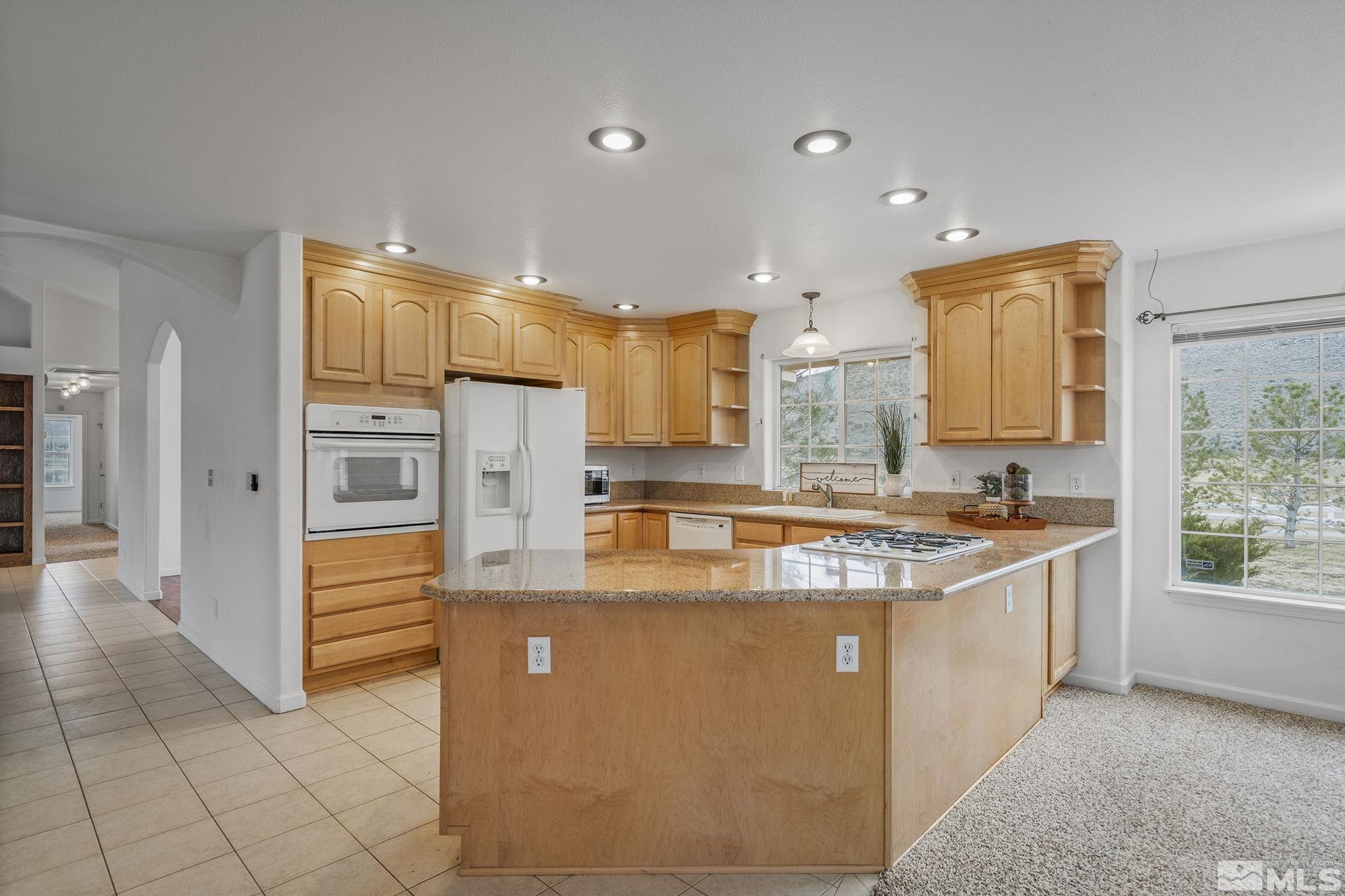 15560 North Red Rock Road Reno, NV 89508 - Photo 13 of 28 a large kitchen with stainless steel appliances granite countertop a sink and cabinets