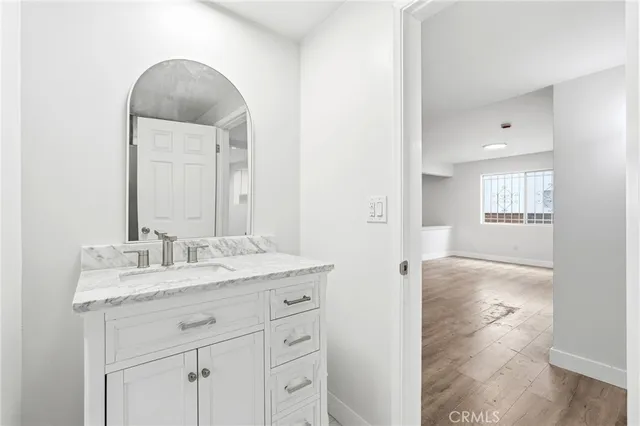 a bathroom with a granite countertop toilet a sink and a mirror