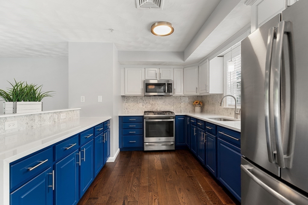 2 Ricciuti Drive, Unit 9 Quincy, MA 02169 - Photo 15 of 40 a kitchen with stainless steel appliances granite countertop a stove a sink dishwasher a refrigerator and a microwave oven