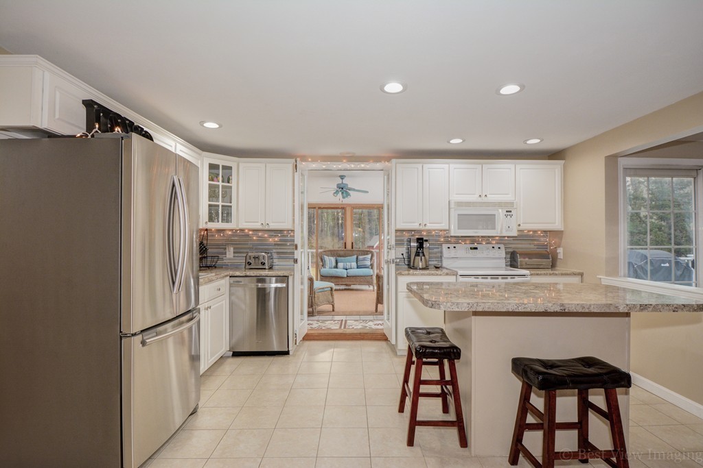 86 Harvard Road Stow, MA 01775 - Photo 6 of 19 a kitchen with stainless steel appliances granite countertop a refrigerator and a stove top oven