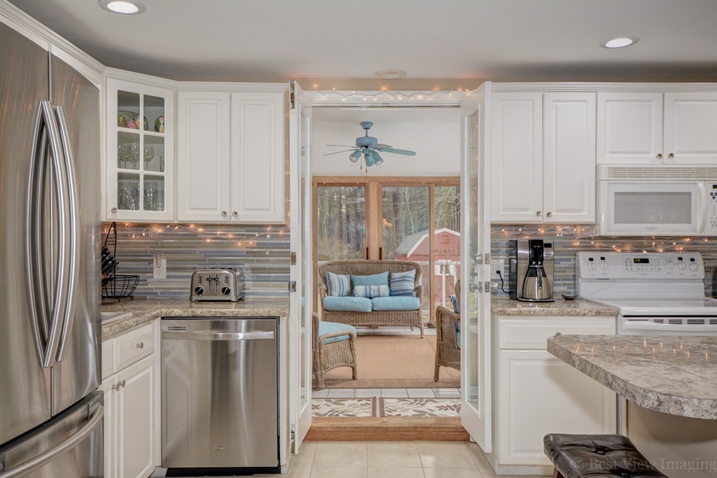 86 Harvard Road Stow, MA 01775 - Photo 8 of 19 a kitchen with stainless steel appliances granite countertop a stove oven and a refrigerator with cabinets