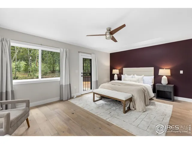 a bedroom with a large bed and wooden floor