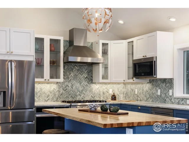 a kitchen with stainless steel appliances granite countertop a sink refrigerator and microwave