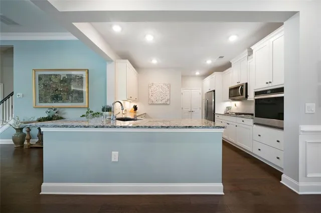 a view of living room with stainless steel appliances granite countertop furniture a fireplace and a flat screen tv