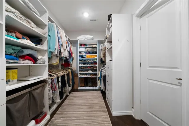 a view of walk in closet with clothes and shoes