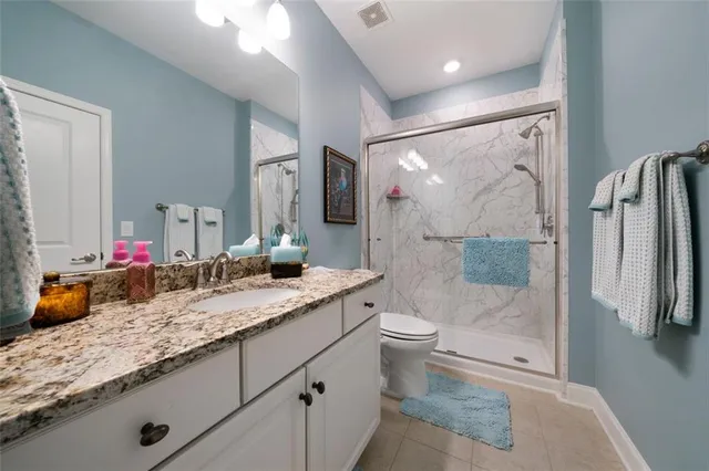 a bathroom with a granite countertop sink toilet and shower