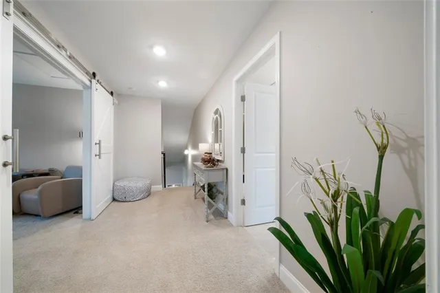 a view of a hallway with furniture and a potted plant