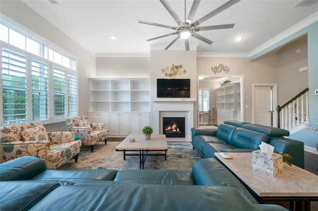 a living room with furniture fireplace and a large window