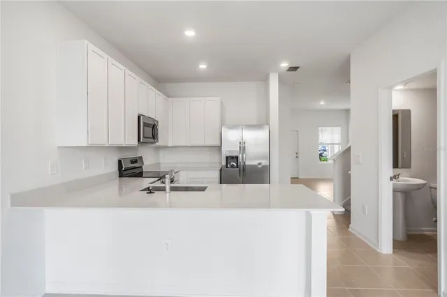 a kitchen with stainless steel appliances a stove sink and microwave