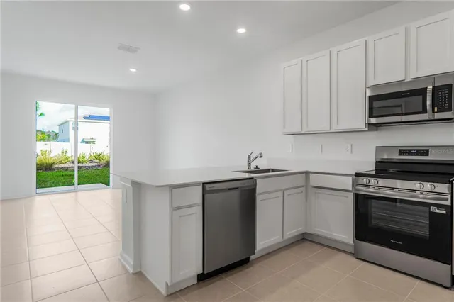 a kitchen with cabinets stainless steel appliances and a sink