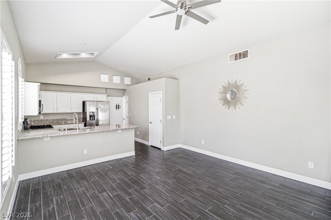9523 Observer Street Las Vegas, NV 89123 - Photo 16 of 42 An open-concept living space integrates a well-appointed kitchen with vaulted ceilings and plank tile flooring.