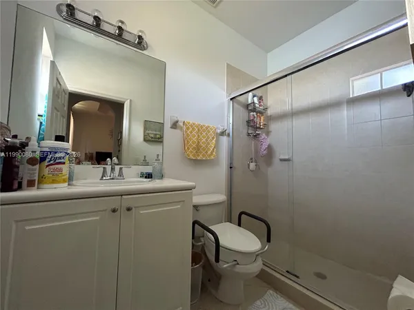 a bathroom with a granite countertop sink toilet and shower