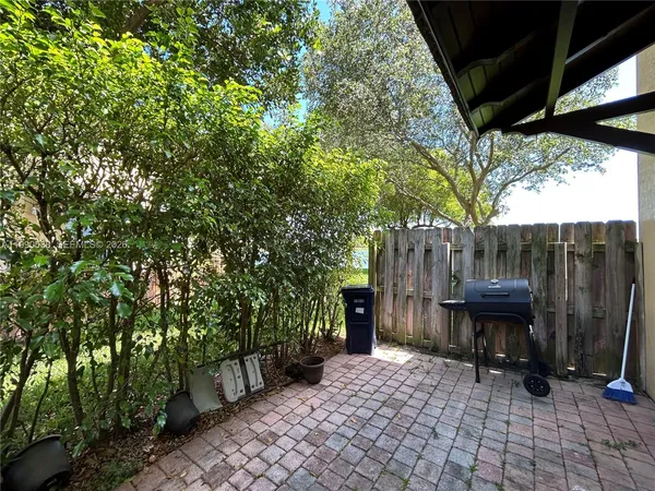 a view of a patio with table and chairs with wooden fence and plants