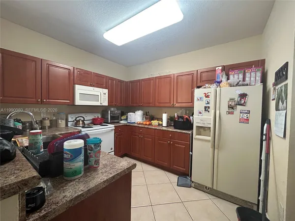 a kitchen with stainless steel appliances granite countertop a refrigerator and a stove