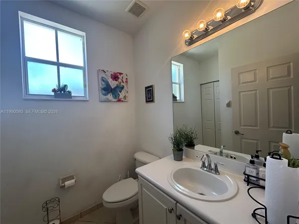 a bathroom with a sink vanity mirror and toilet