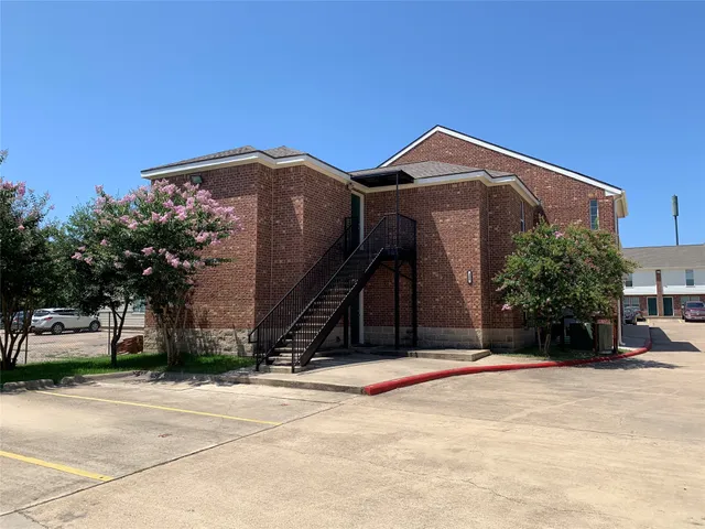a view of a house with a garden and car parked