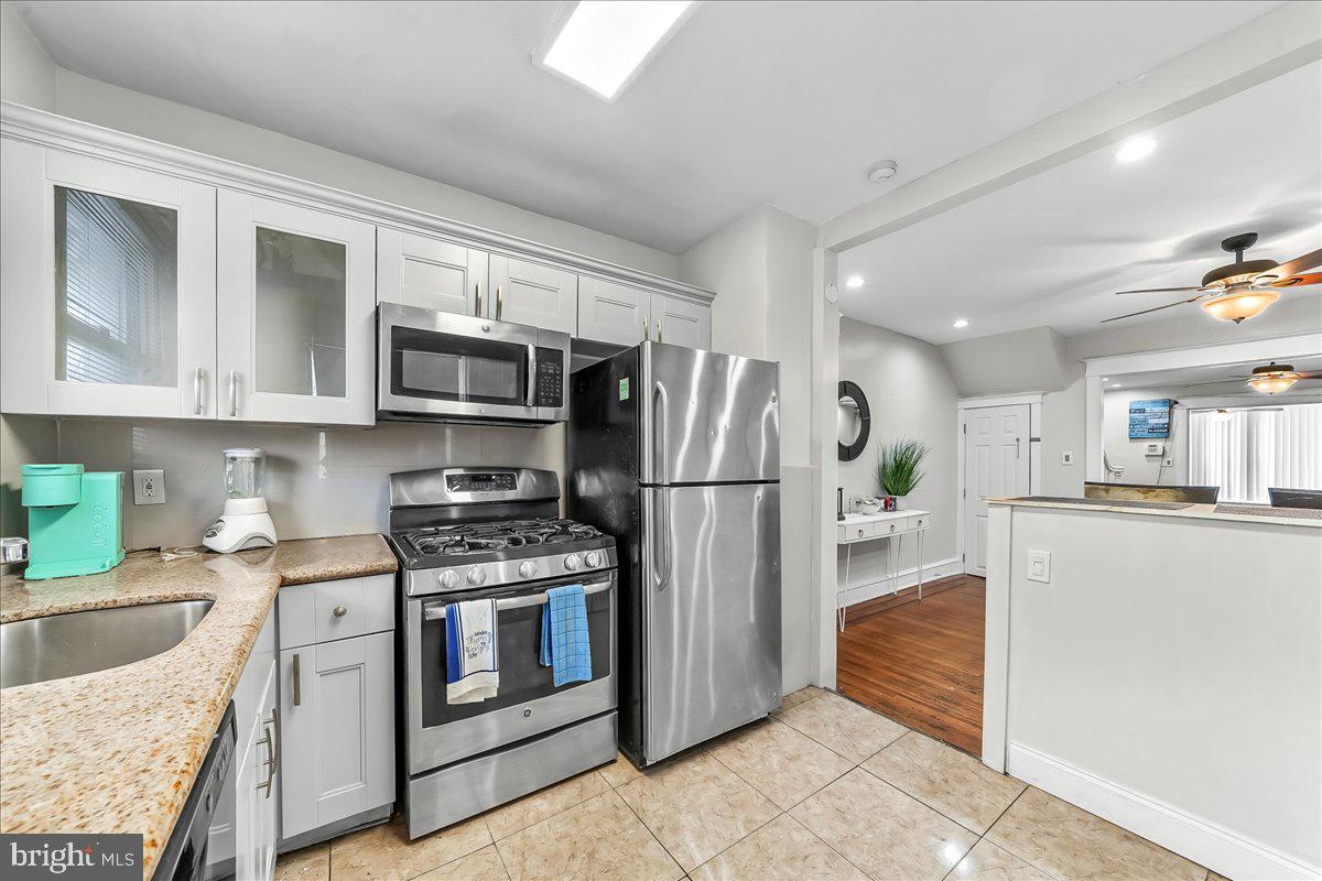 5348 West Berks Street Philadelphia, PA 19131 - Photo 8 of 18 a kitchen with stainless steel appliances granite countertop a refrigerator stove and sink