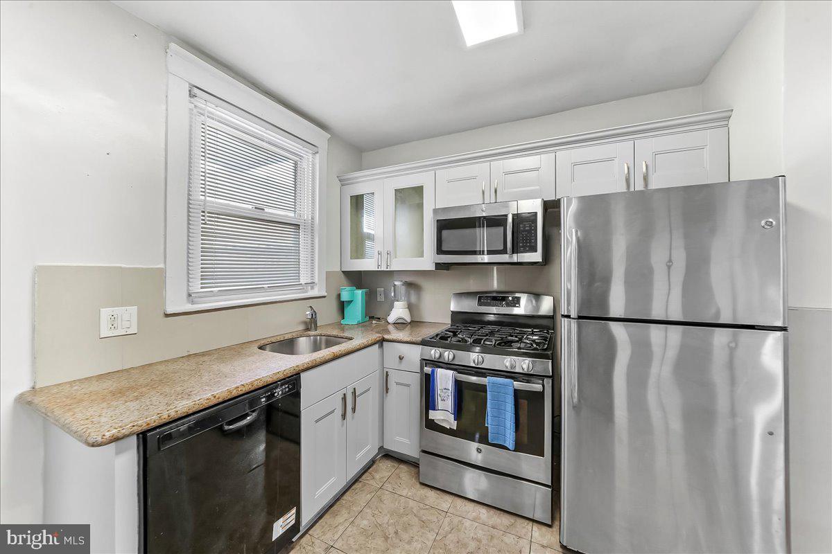 5348 West Berks Street Philadelphia, PA 19131 - Photo 9 of 18 a kitchen with stainless steel appliances granite countertop a refrigerator sink stove microwave and cabinets