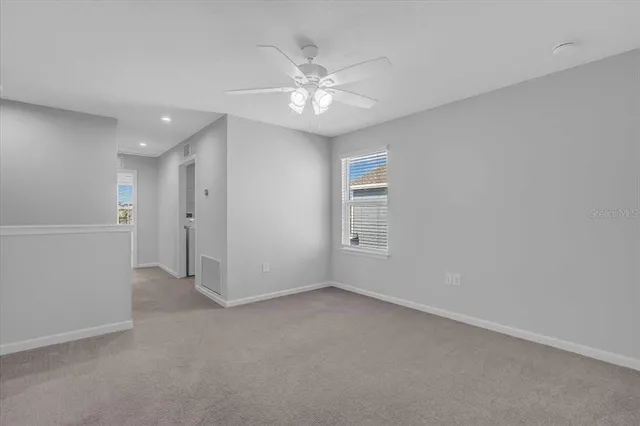 an empty room with closet and a ceiling fan