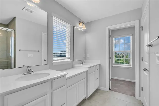 a bathroom with double sink and a mirror
