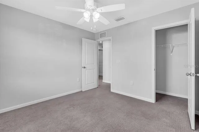 an empty room with a ceiling fan and a window
