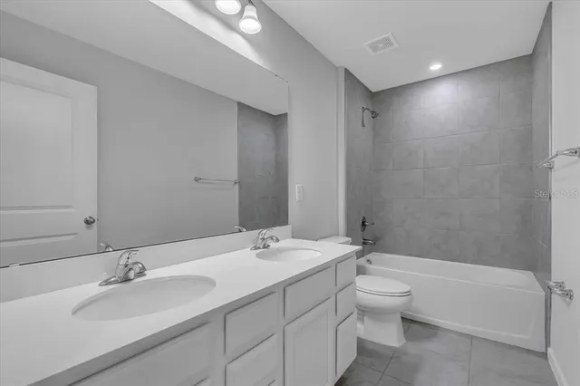 a bathroom with a double vanity sink toilet and shower