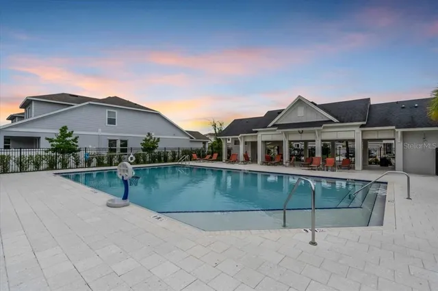 a front view of a house with a garden and lake view