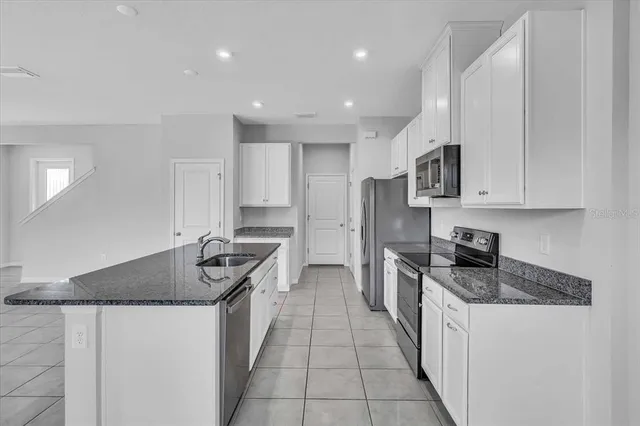 a kitchen with stainless steel appliances granite countertop a sink stove and cabinets