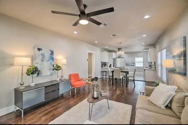 a living room with furniture kitchen view and a chandelier