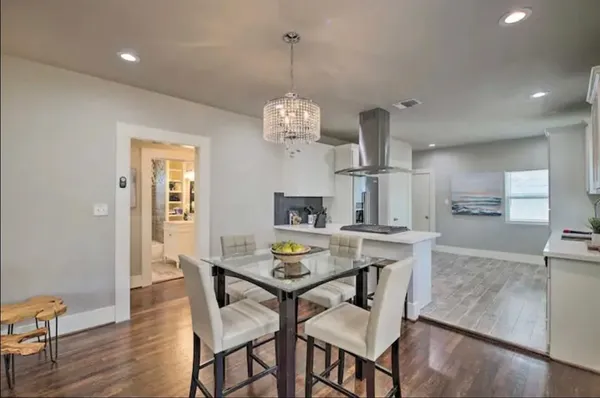 a view of a dining room with furniture a chandelier and wooden floor