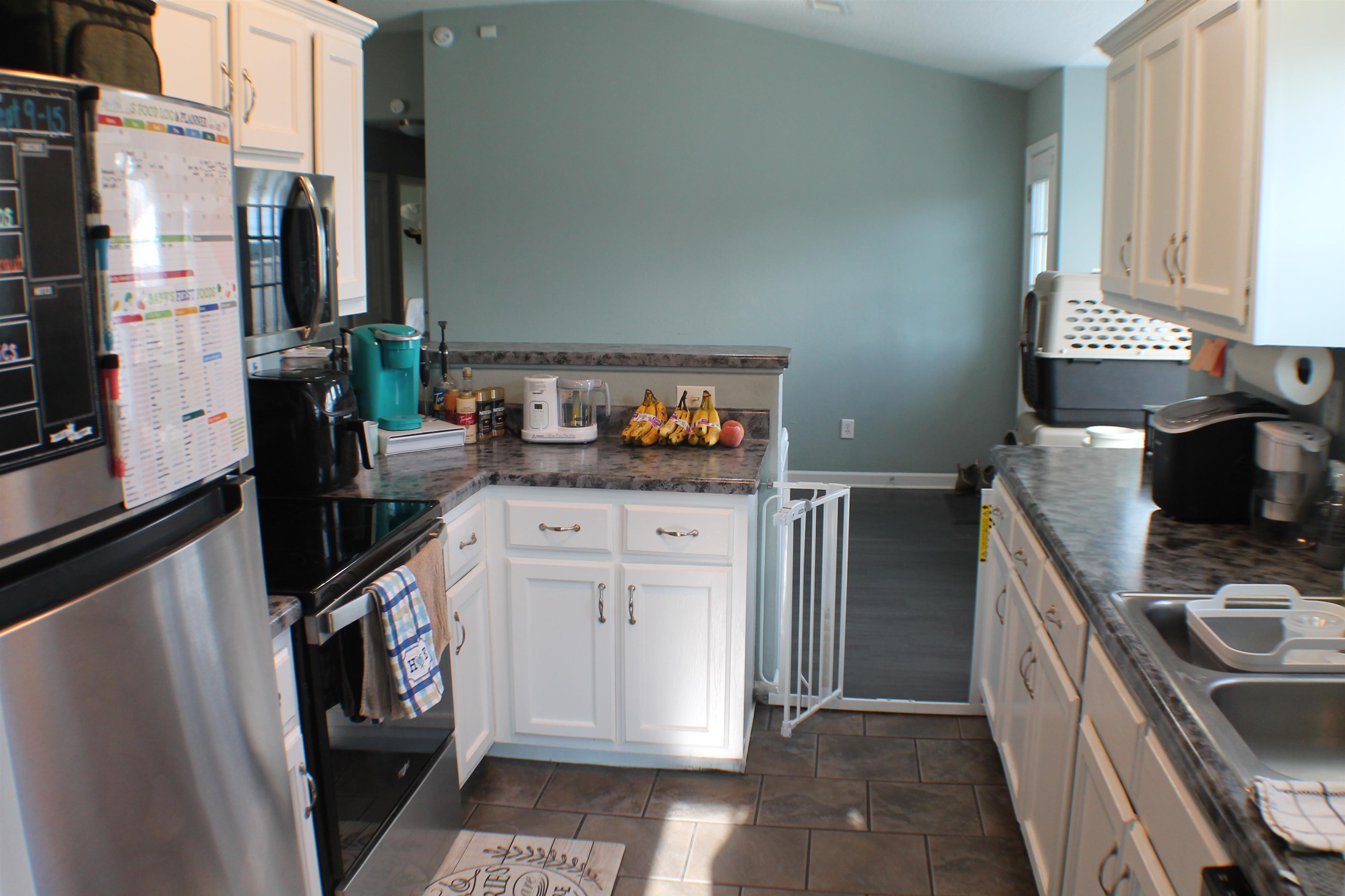 75 Springview Street Mason, TN 38049 - Photo 6 of 14 Kitchen featuring stainless steel appliances, dark stone counters, white cabinets, and dark tile patterned flooring