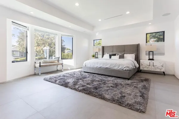 a bedroom with a large bed and a large window
