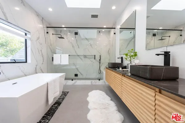 a large white tub sitting in a bathroom next to a window