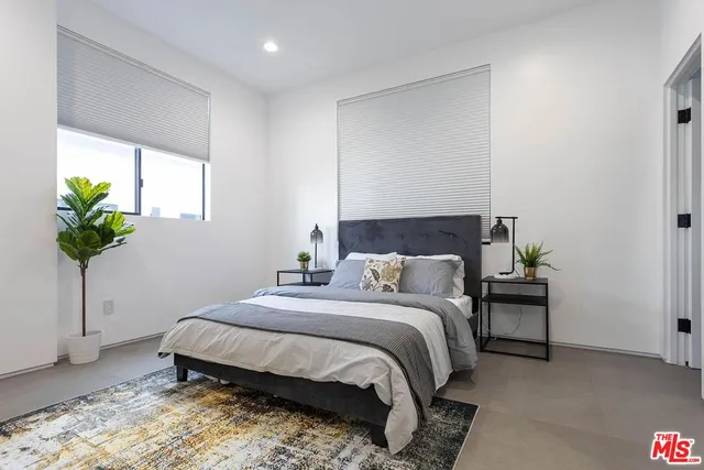 a bedroom with a bed and a potted plant