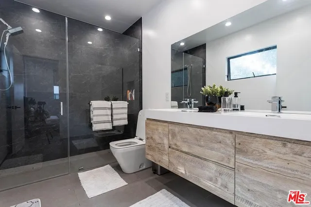 a bathroom with a double vanity sink toilet and shower
