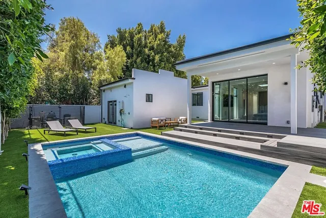a view of a house with swimming pool and sitting area