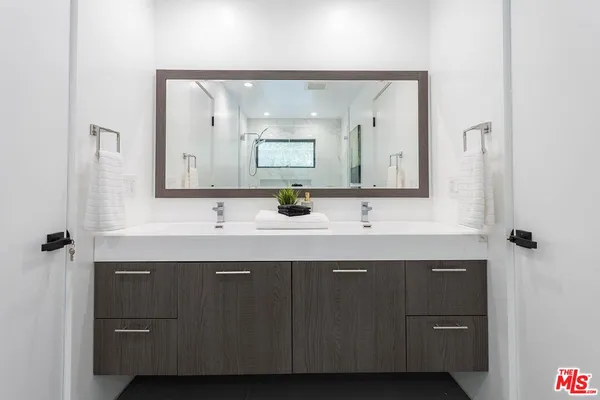 a bathroom with a double vanity sink and mirror