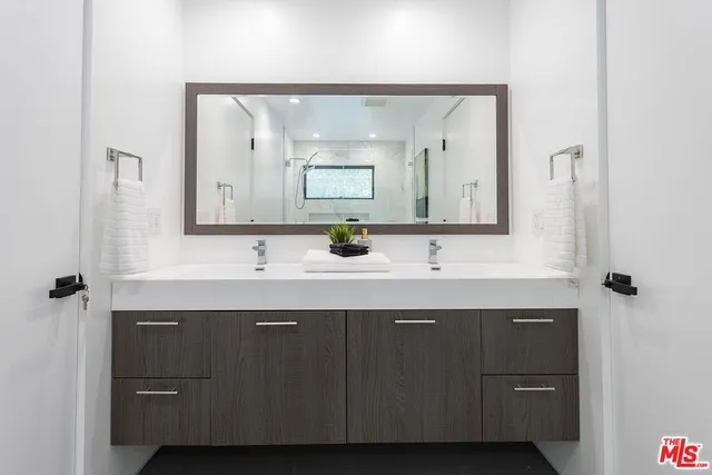 a bathroom with a double vanity sink and mirror